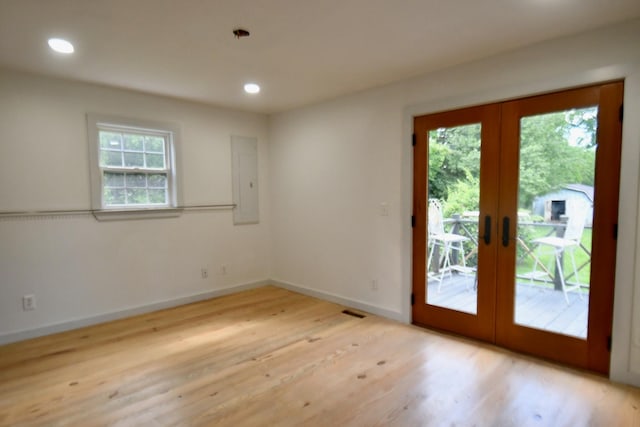 spare room with french doors, plenty of natural light, light wood-style floors, recessed lighting, and baseboards