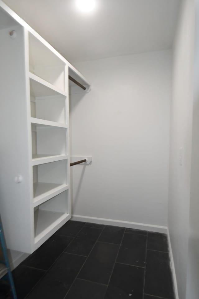 spacious closet with dark tile patterned flooring