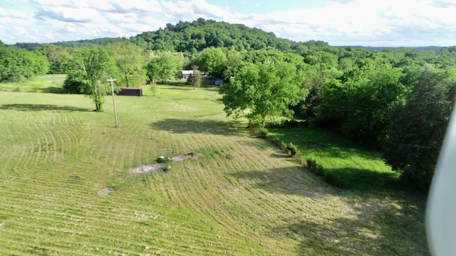 view of property location with a forest