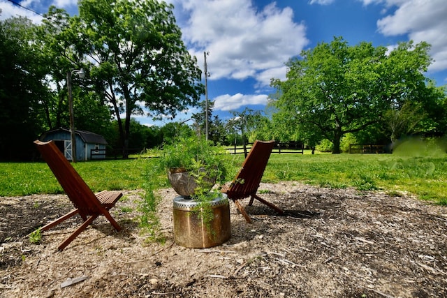 view of yard featuring an outdoor structure, a storage unit, and view of scattered trees