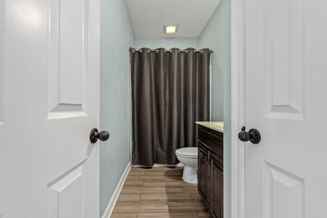 1165 Short Springs Rd, Tullahoma, TN 37388 - full bathroom with vanity, toilet, wood finished floors, a shower with shower curtain, and baseboards