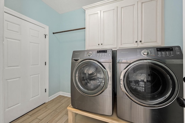 1165 Short Springs Rd, Tullahoma, TN 37388 - clothes washing area with washer and dryer, cabinet space, light wood-style flooring, and baseboards