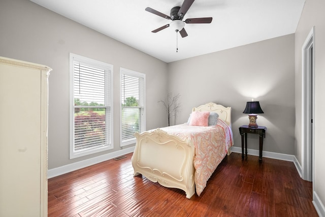 bedroom with dark wood-type flooring, baseboards, and ceiling fan
