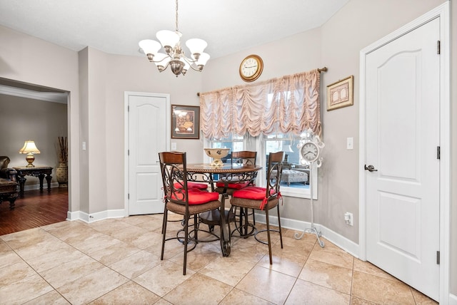 dining area with a chandelier, tile patterned floors, and baseboards