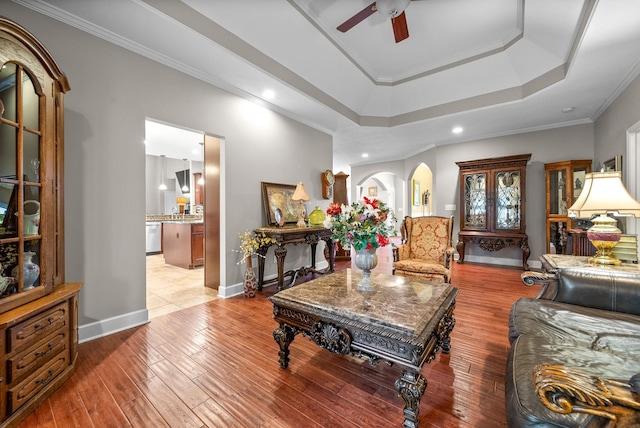 living room with ceiling fan, a tray ceiling, hardwood / wood-style floors, recessed lighting, and baseboards