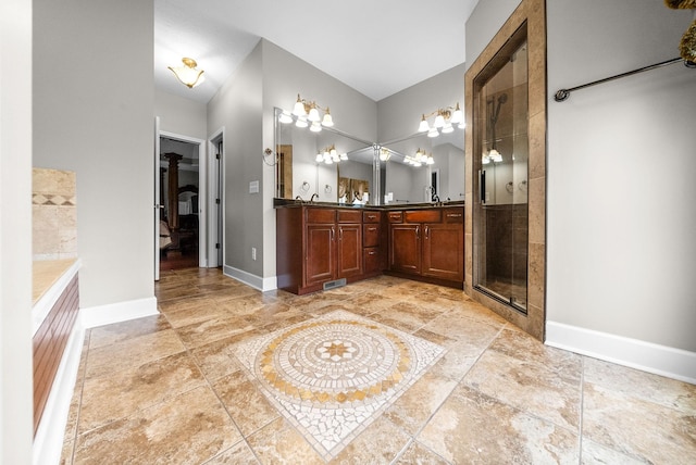 full bath with tiled shower, baseboards, and double vanity