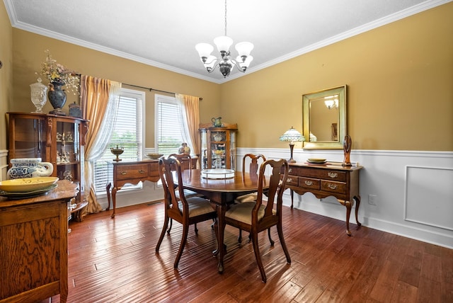 dining space with a chandelier, ornamental molding, a wainscoted wall, and wood-type flooring
