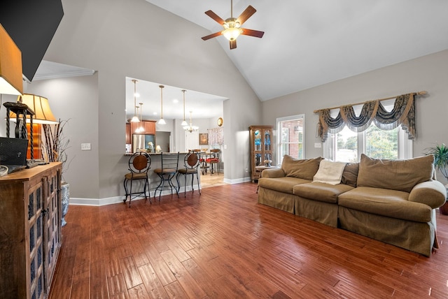 living room with ceiling fan, high vaulted ceiling, wood finished floors, a chandelier, and baseboards