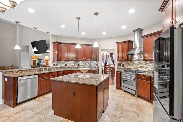 kitchen with appliances with stainless steel finishes, wall chimney exhaust hood, a sink, a center island, and decorative backsplash