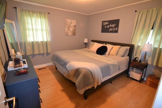 800 E Grigsby St, Pulaski, TN 38478 - bedroom featuring light wood-type flooring, multiple windows, crown molding, and baseboards
