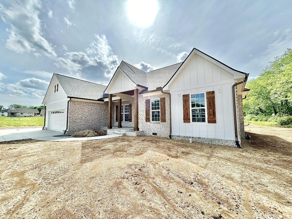 24 Hurst Dr, Leoma, TN 38468 - modern inspired farmhouse featuring board and batten siding, an attached garage, concrete driveway, and brick siding