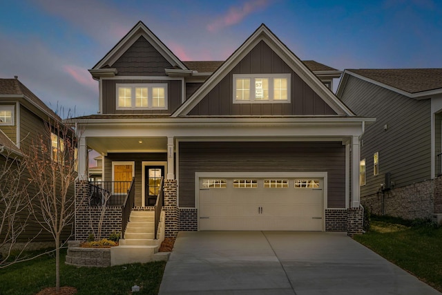 craftsman house with board and batten siding, covered porch, concrete driveway, a garage, and brick siding