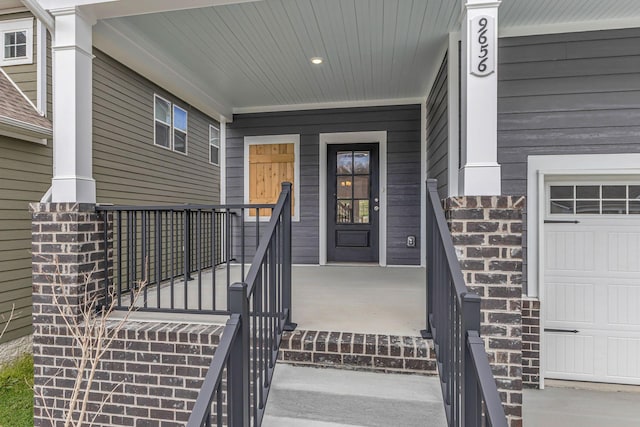 doorway to property with covered porch and a garage