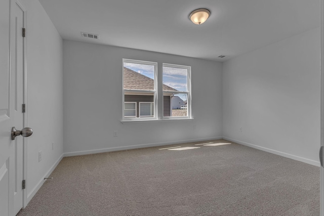 carpeted spare room featuring baseboards