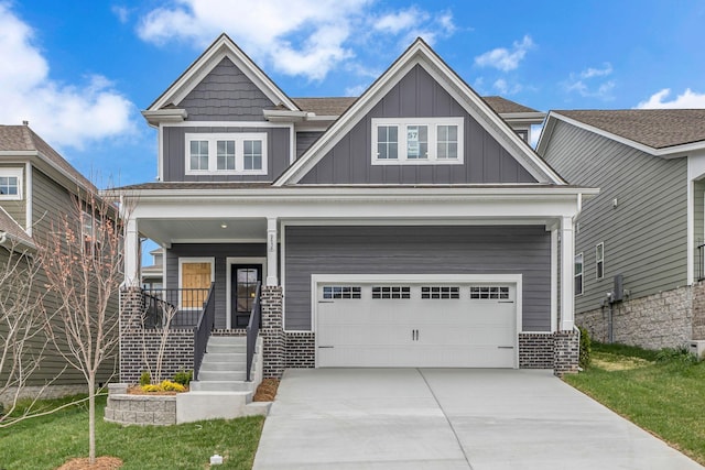 craftsman-style house featuring covered porch, board and batten siding, concrete driveway, an attached garage, and brick siding