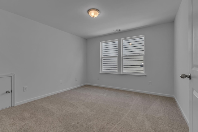 unfurnished room featuring light colored carpet and baseboards
