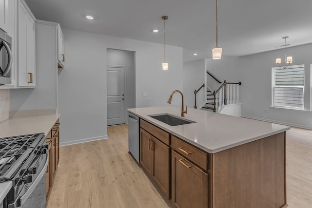 kitchen featuring a sink, stainless steel appliances, white cabinetry, light wood-style flooring, and recessed lighting