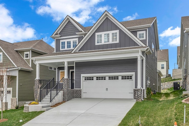 craftsman inspired home featuring board and batten siding, a garage, central AC unit, driveway, and a front lawn