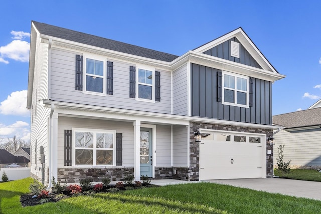 craftsman-style house featuring board and batten siding, concrete driveway, stone siding, an attached garage, and a front yard