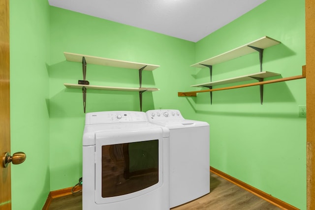 washroom featuring separate washer and dryer, wood finished floors, and baseboards