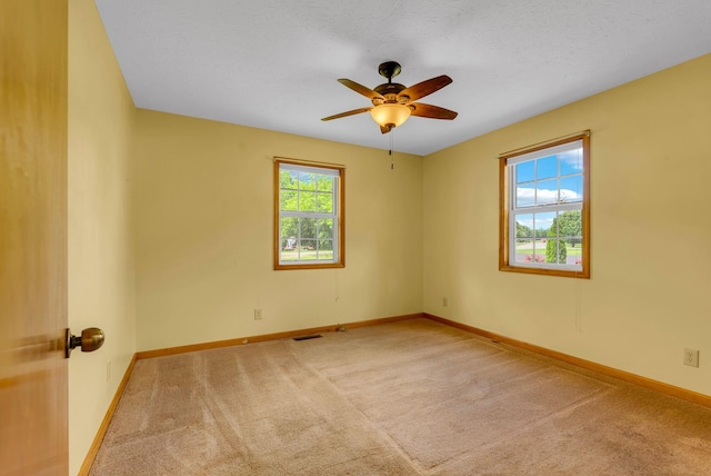 carpeted empty room with baseboards and ceiling fan
