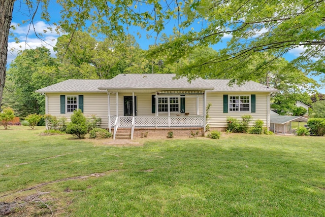 ranch-style house featuring a front yard, covered porch, and a shingled roof