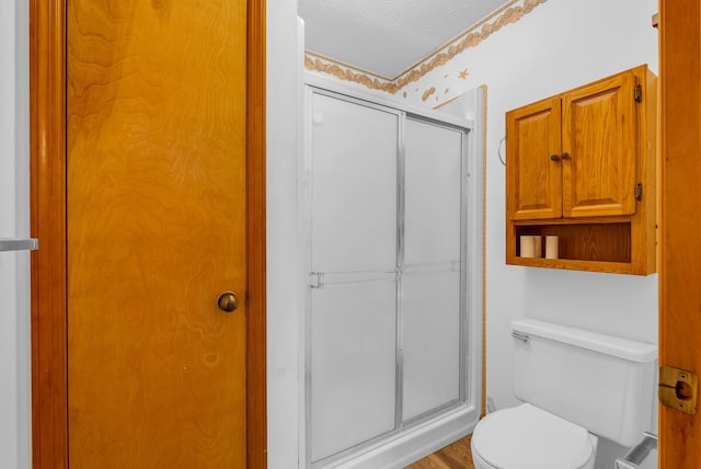 full bathroom with a stall shower and toilet