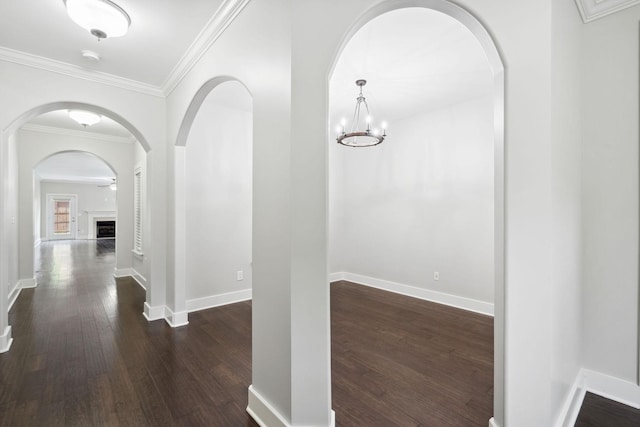 1000 Swanson Ln, Franklin, TN 37064 - hallway with dark wood finished floors, arched walkways, ornamental molding, baseboards, and a chandelier