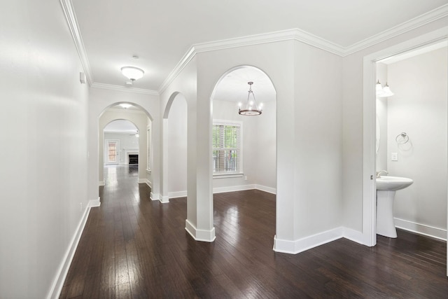 1000 Swanson Ln, Franklin, TN 37064 - hallway featuring dark wood-type flooring, arched walkways, baseboards, crown molding, and a chandelier