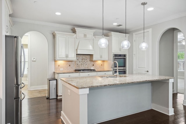 1000 Swanson Ln, Franklin, TN 37064 - kitchen with appliances with stainless steel finishes, arched walkways, a sink, baseboards, and decorative backsplash