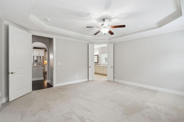 1000 Swanson Ln, Franklin, TN 37064 - unfurnished bedroom with a raised ceiling, arched walkways, crown molding, light colored carpet, and ensuite bath