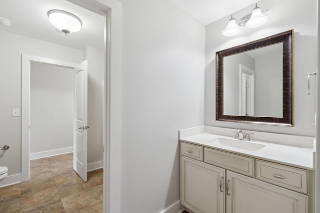 1000 Swanson Ln, Franklin, TN 37064 - bathroom featuring baseboards, vanity, stone finish floors, and toilet