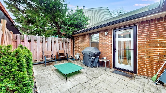 view of patio / terrace featuring a grill and fence