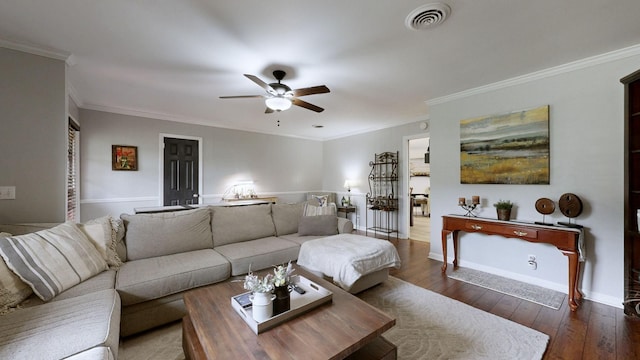living area with a ceiling fan, wood-type flooring, ornamental molding, and baseboards