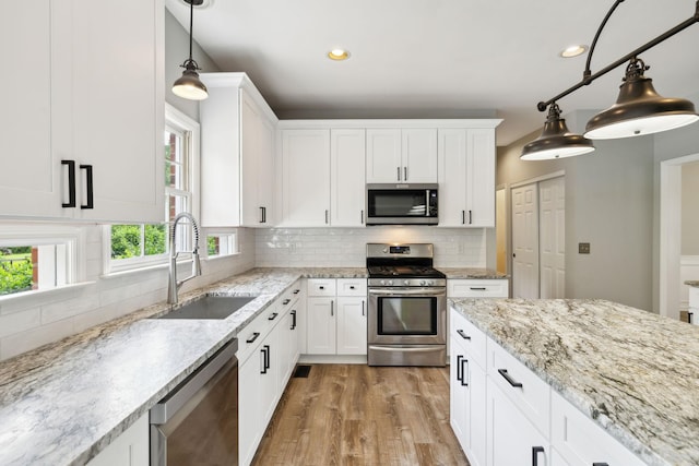 410 Springhouse Ct, Franklin, TN 37067 - kitchen featuring stainless steel appliances, a sink, light wood finished floors, white cabinetry, and recessed lighting