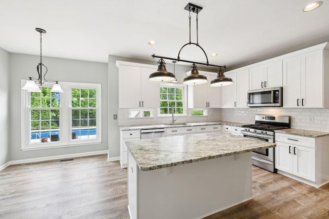 410 Springhouse Ct, Franklin, TN 37067 - kitchen featuring appliances with stainless steel finishes, a sink, a kitchen island, tasteful backsplash, and light wood-type flooring