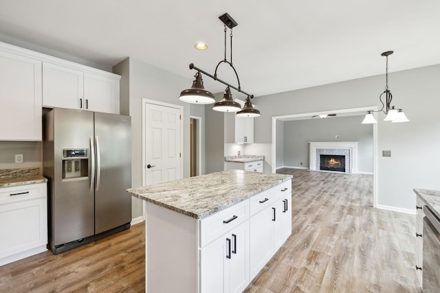 410 Springhouse Ct, Franklin, TN 37067 - kitchen featuring stainless steel fridge, light wood-style flooring, a fireplace, white cabinets, and recessed lighting