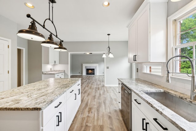 410 Springhouse Ct, Franklin, TN 37067 - kitchen with a sink, stainless steel dishwasher, light wood-style floors, a warm lit fireplace, and recessed lighting