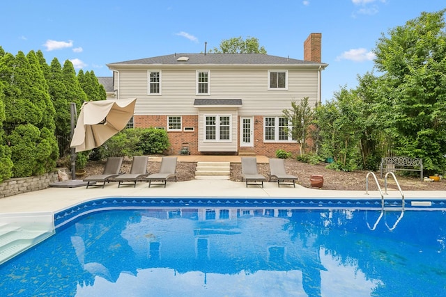 410 Springhouse Ct, Franklin, TN 37067 - back of house featuring brick siding, a patio area, a chimney, and an outdoor pool