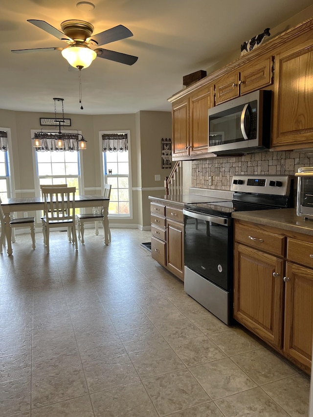 1224 Whiteside Hill Rd, Wartrace, TN 37183 - kitchen with stainless steel appliances, decorative backsplash, ceiling fan, and brown cabinetry