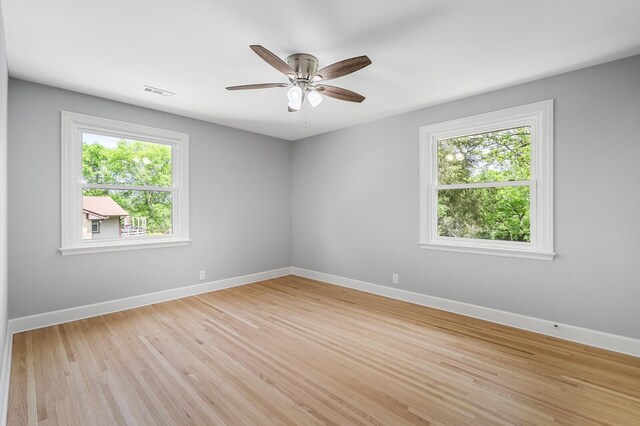 unfurnished room featuring plenty of natural light, baseboards, light wood finished floors, and a ceiling fan