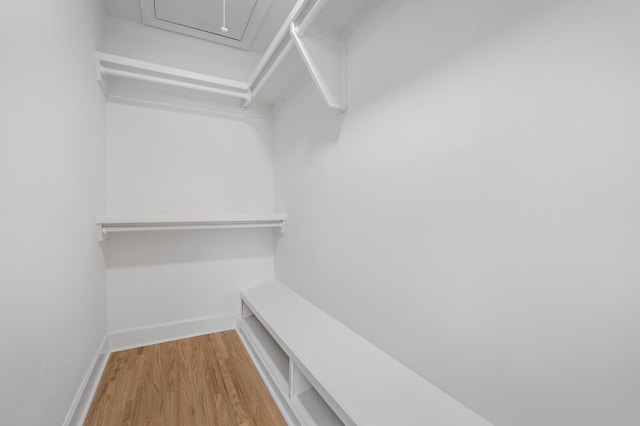 spacious closet with wood finished floors and attic access