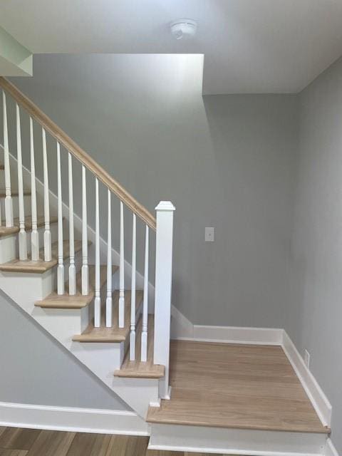 stairway featuring wood finished floors and baseboards