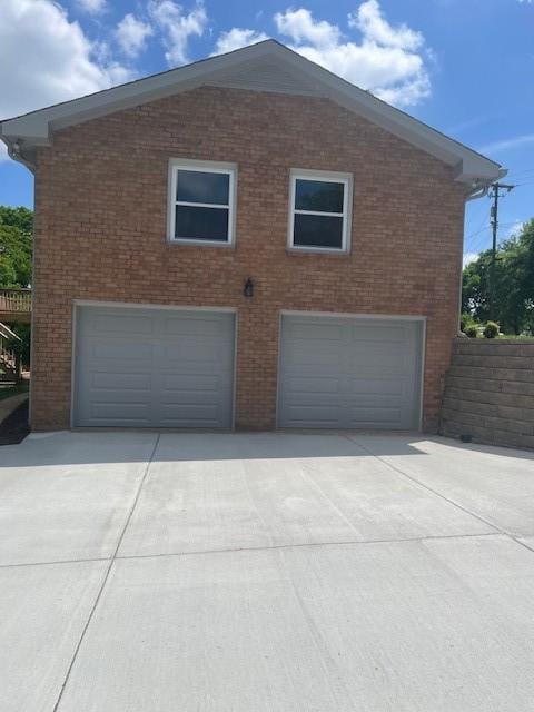 view of home's exterior featuring brick siding and driveway