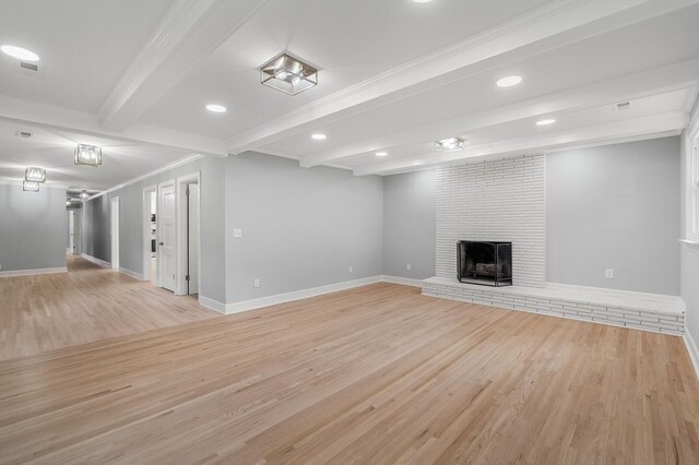 unfurnished living room featuring light wood-type flooring, a brick fireplace, beam ceiling, baseboards, and recessed lighting
