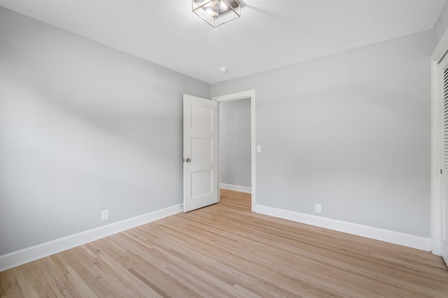 empty room featuring baseboards and light wood-type flooring