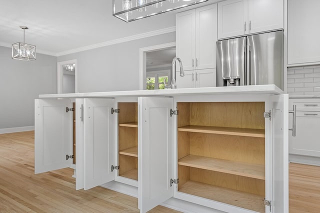 kitchen view of open shelves, stainless steel refrigerator with ice dispenser, crown molding, light wood-type flooring, and white cabinetry