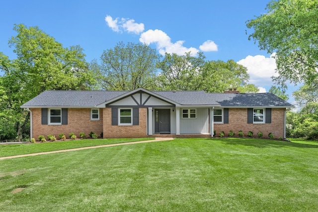 single story home featuring brick siding, a front lawn, a chimney, and a shingled roof