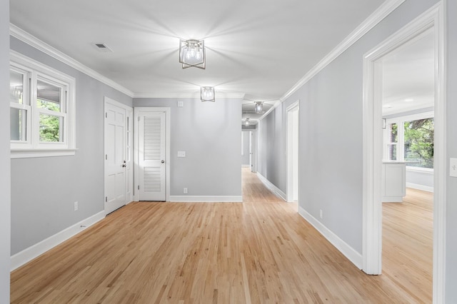 spare room with light wood-style flooring, baseboards, and ornamental molding