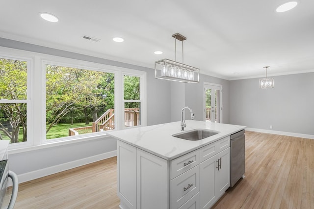 kitchen featuring a sink, stainless steel dishwasher, baseboards, plenty of natural light, and crown molding